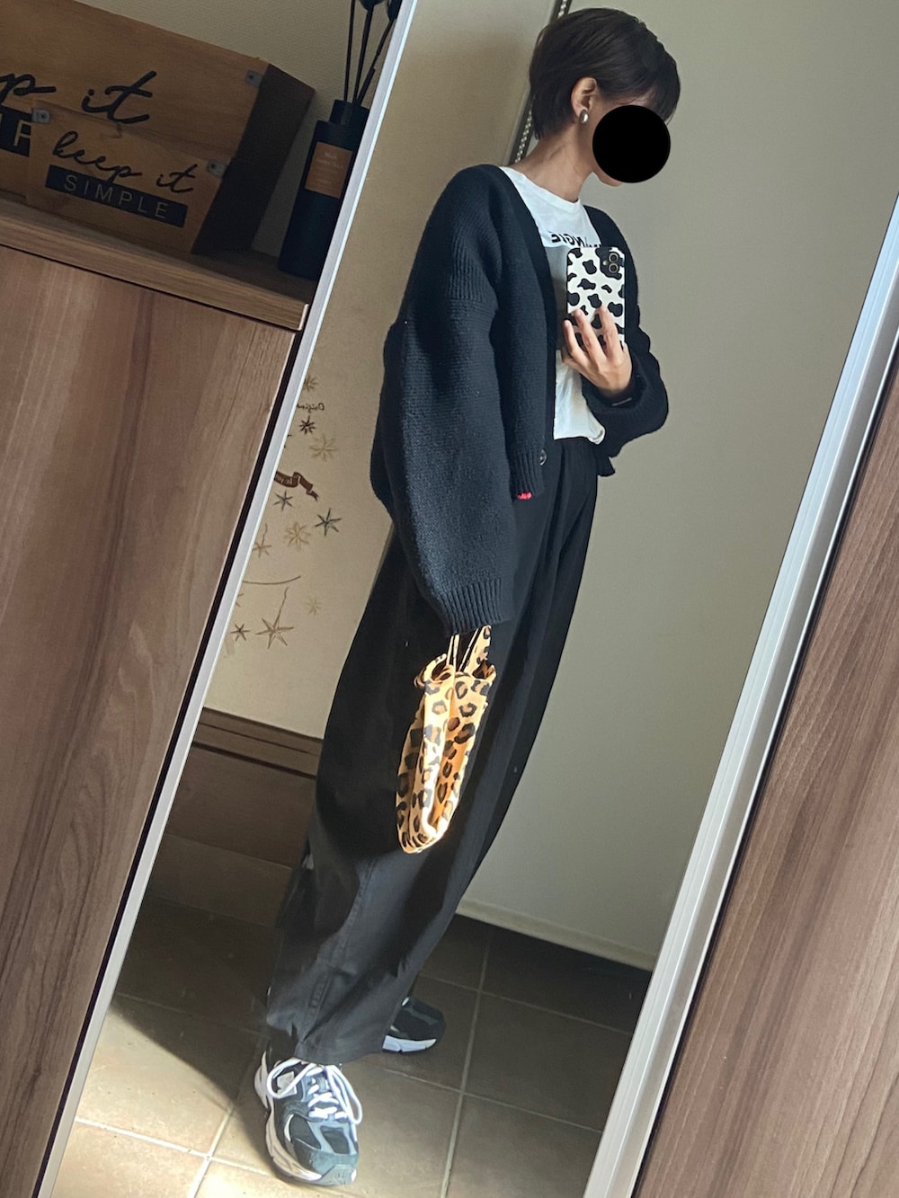 ホワイト系のTシャツ/カットソー、ブラック系のカーディガン/ボレロ、ブラック系のパンツを着用したレディースの秋コーディネートの4枚目の写真