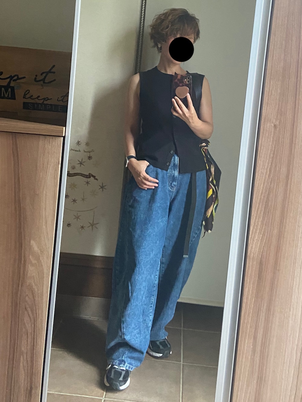 ブラック系のベスト、ブルー系のデニムパンツ、ブラック系のショルダーバッグを着用したレディースの夏コーディネートの4枚目の写真