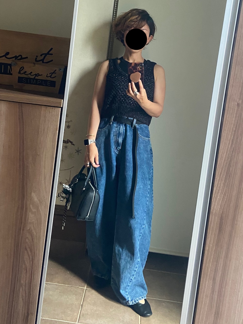 ブルー系のデニムパンツ、ブラック系のバッグ、ブラック系のベストを着用したレディースの夏コーディネートの3枚目の写真
