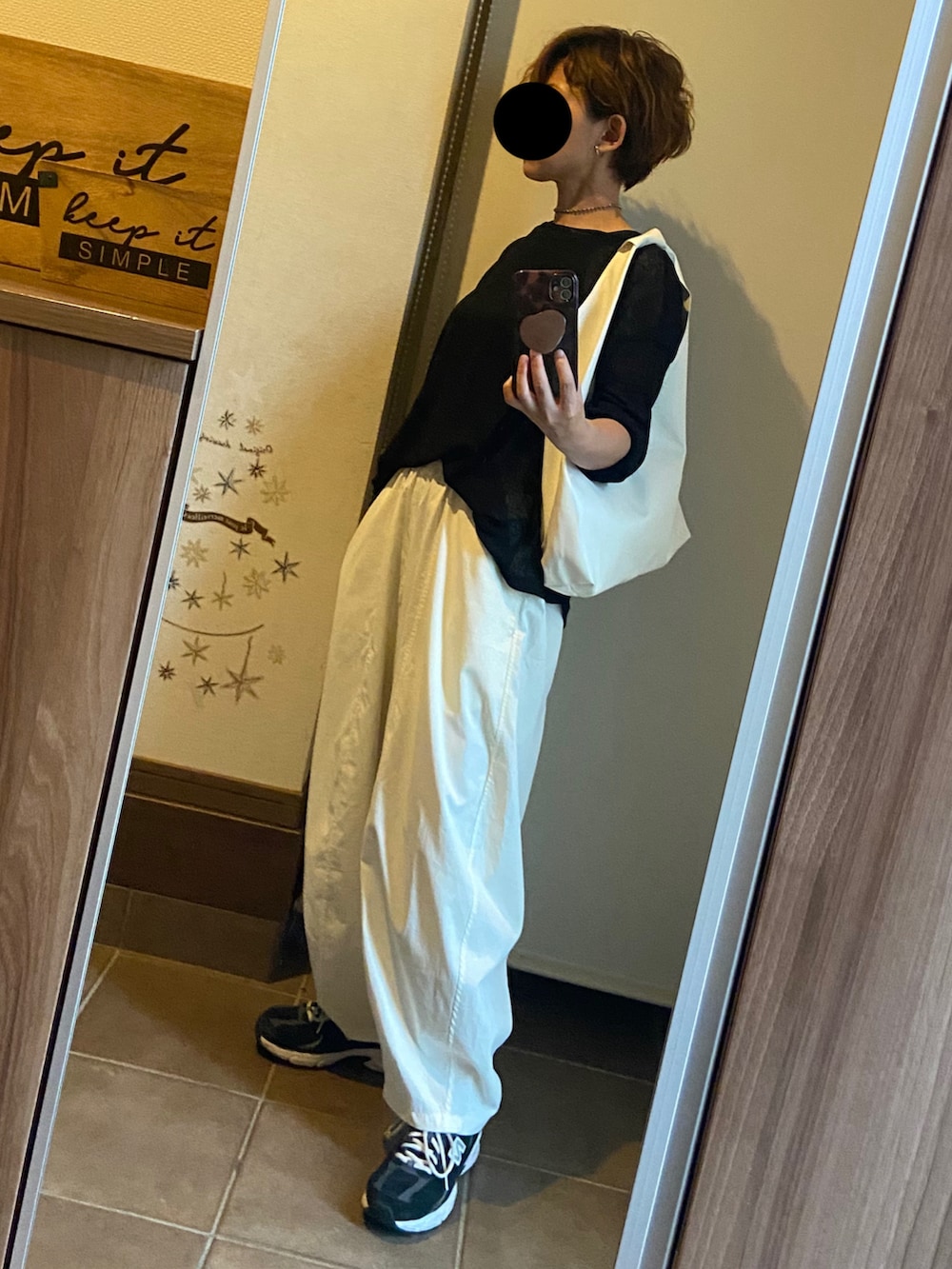 ブラック系のニット/セーター、ホワイト系のその他パンツ、ホワイト系のトートバッグを着用したレディースの夏コーディネートの2枚目の写真