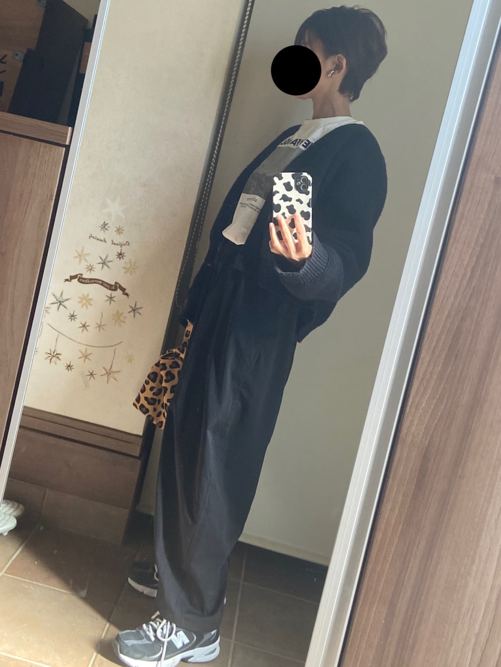 ホワイト系のTシャツ/カットソー、ブラック系のカーディガン/ボレロ、ブラック系のパンツを着用したレディースの秋コーディネートの2枚目の写真