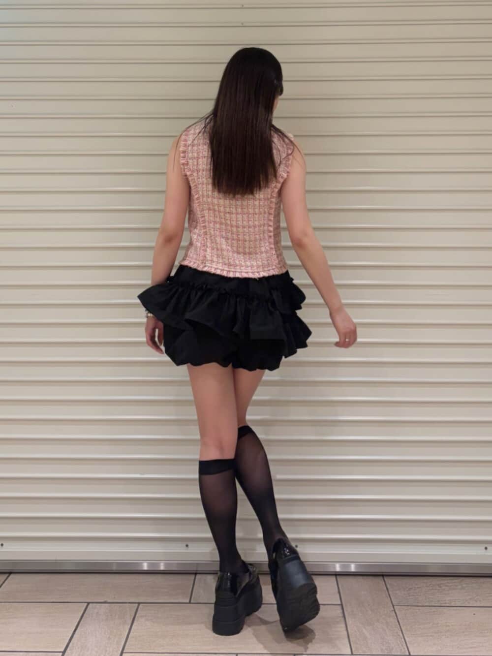 ピンク系のベスト、ブラック系のその他パンツを着用したレディースの夏コーディネートの4枚目の写真