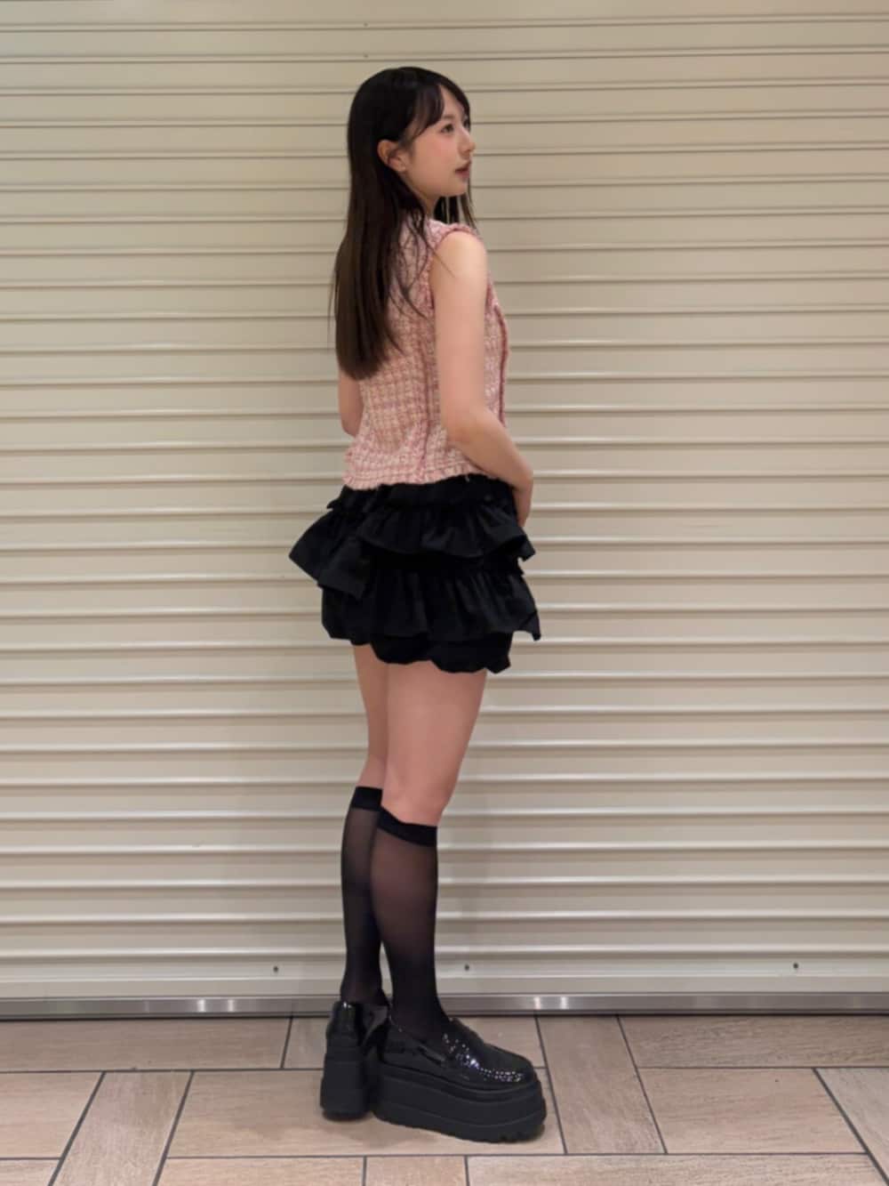 ピンク系のベスト、ブラック系のその他パンツを着用したレディースの夏コーディネートの3枚目の写真