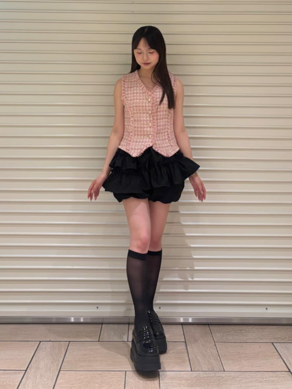 ピンク系のベスト、ブラック系のその他パンツを着用したレディースの夏コーディネートの2枚目の写真