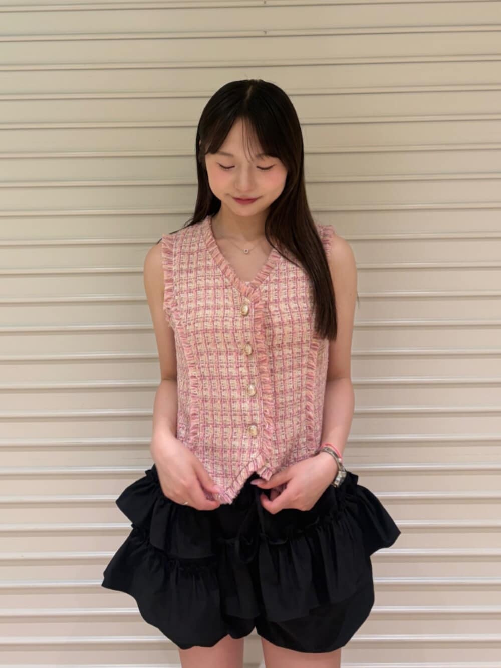 ピンク系のベスト、ブラック系のその他パンツを着用したレディースの夏コーディネートの5枚目の写真