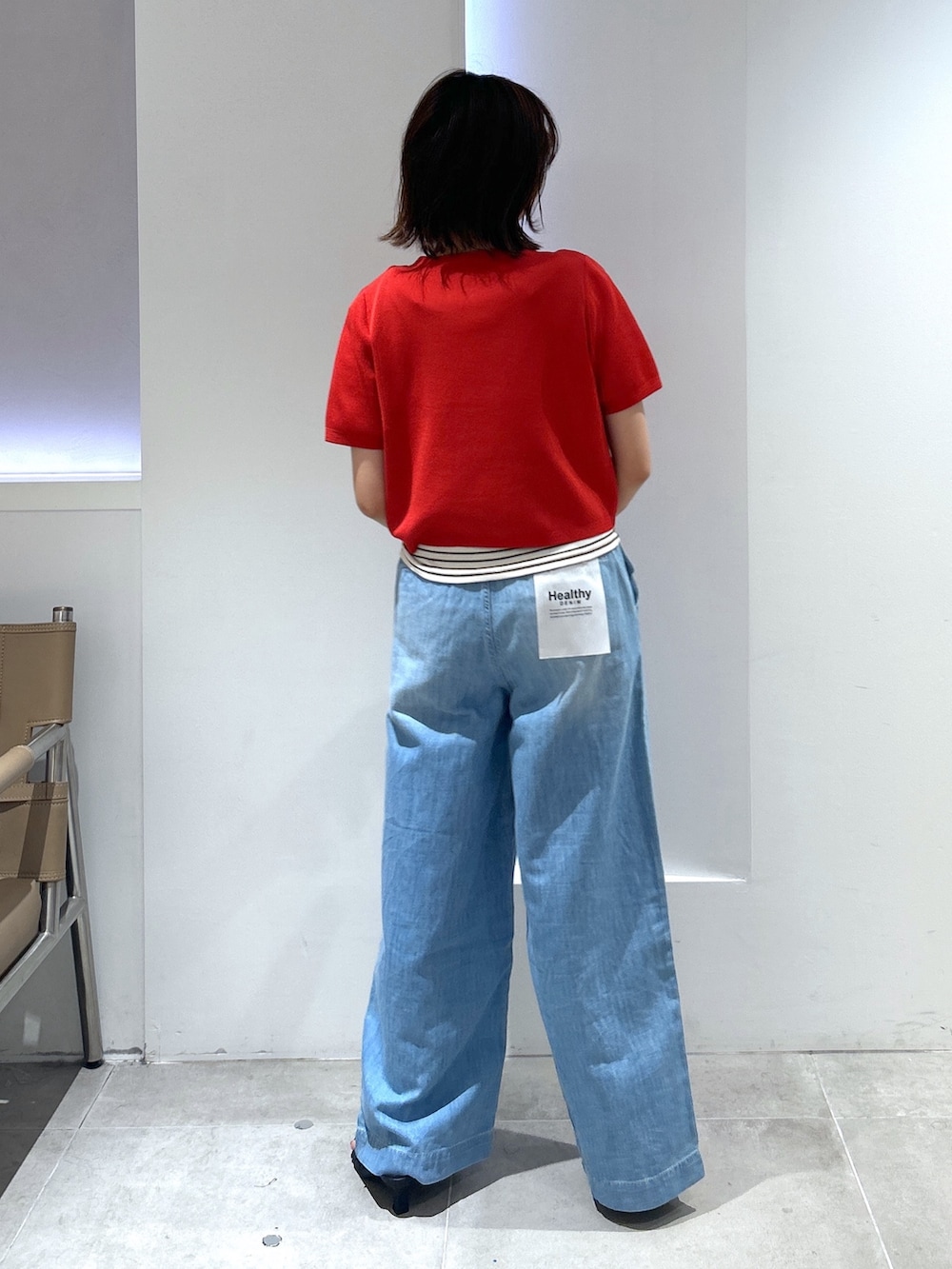 レッド系のカーディガン/ボレロ、ブルー系のデニムパンツを着用したレディースの夏コーディネートの3枚目の写真