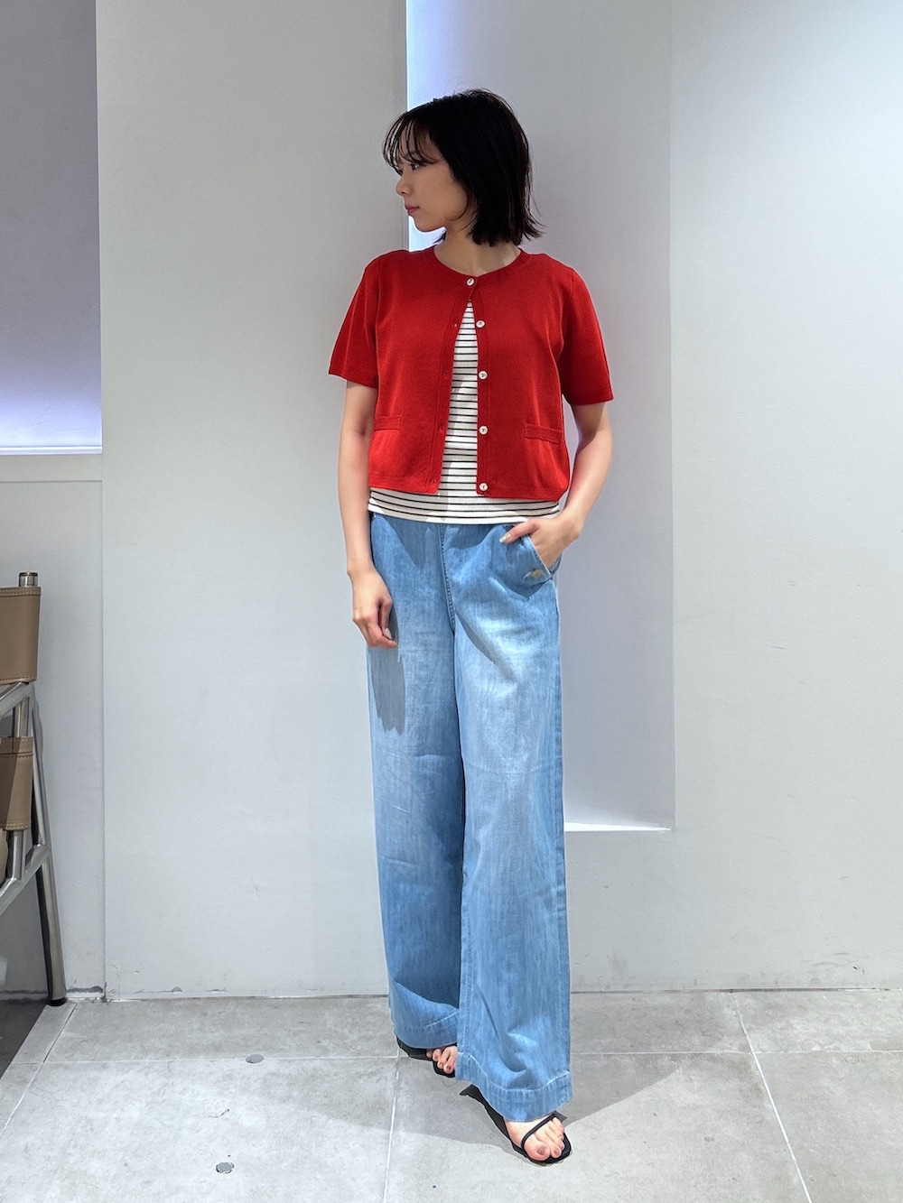 レッド系のカーディガン/ボレロ、ブルー系のデニムパンツを着用したレディースの夏コーディネートの2枚目の写真