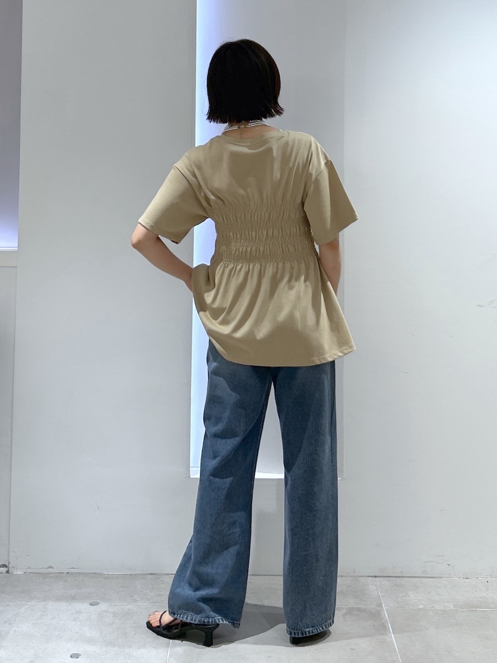 ベージュ系のTシャツ/カットソー、ブルー系のデニムパンツを着用したレディースの夏コーディネートの4枚目の写真
