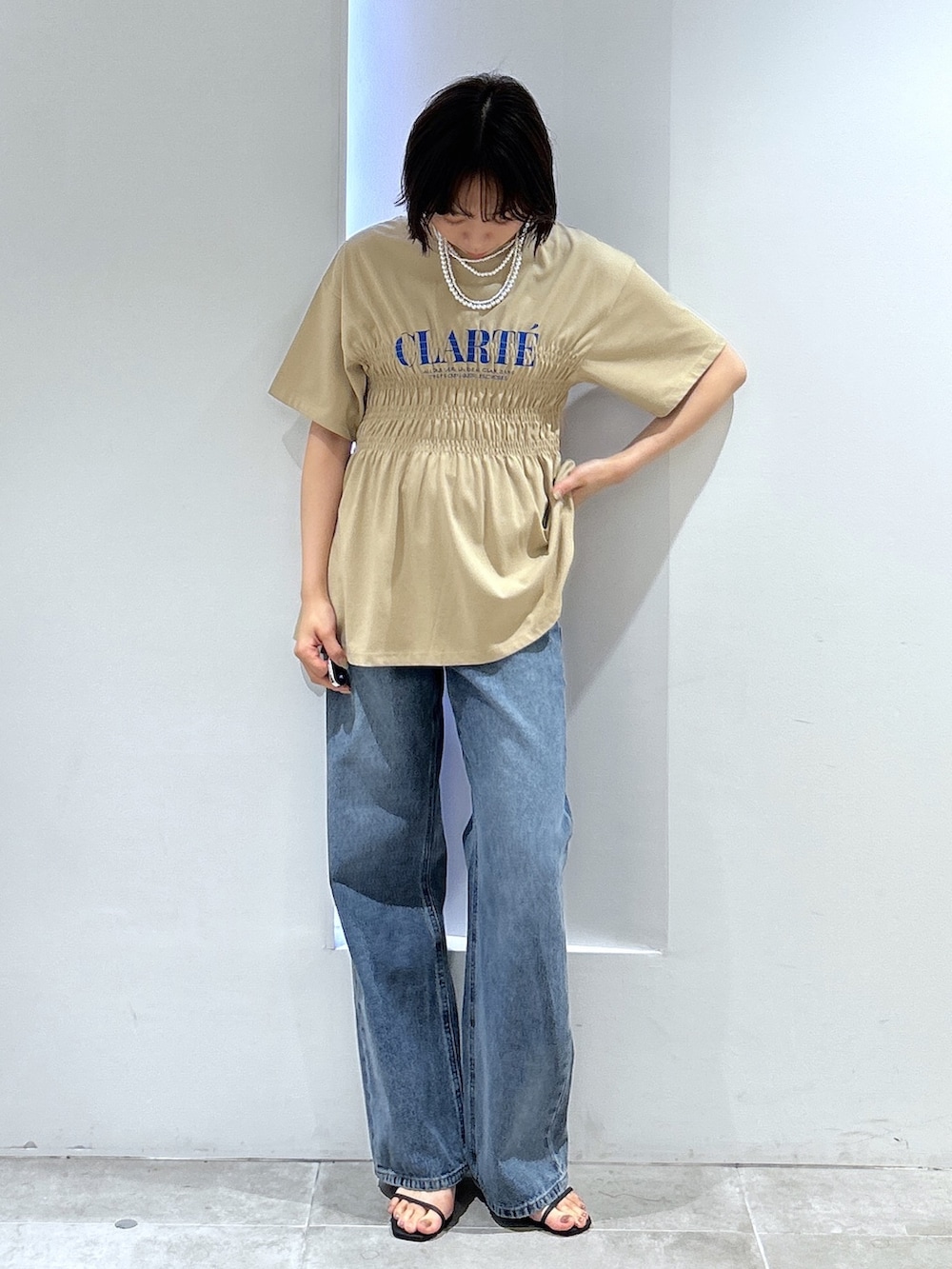 ベージュ系のTシャツ/カットソー、ブルー系のデニムパンツを着用したレディースの夏コーディネートの2枚目の写真