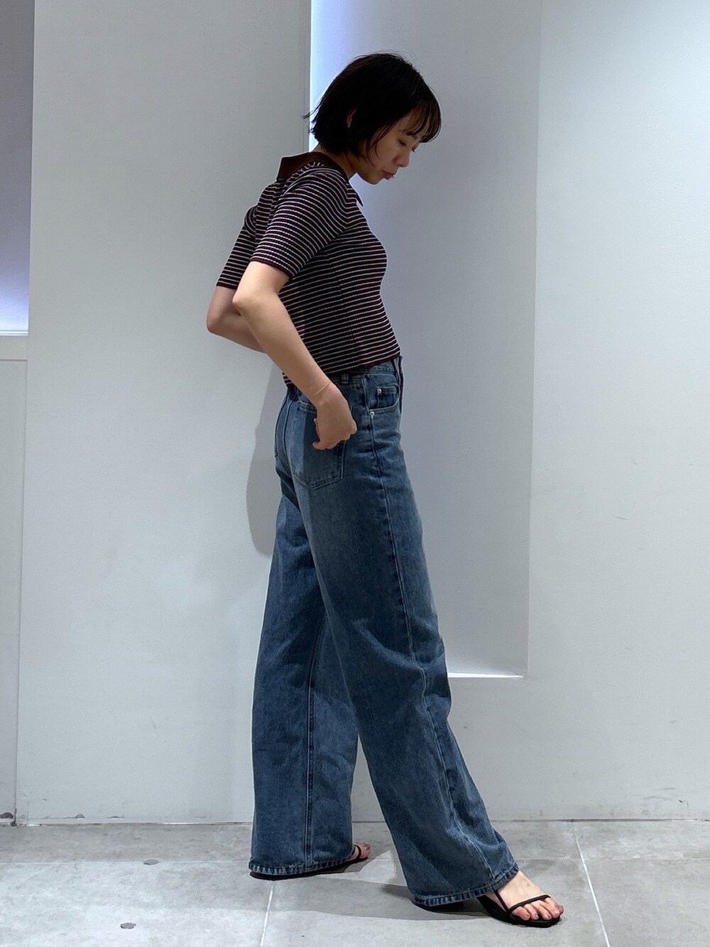 ブルー系のデニムパンツ、ブラウン系のワンピースを着用したレディースの夏コーディネートの3枚目の写真