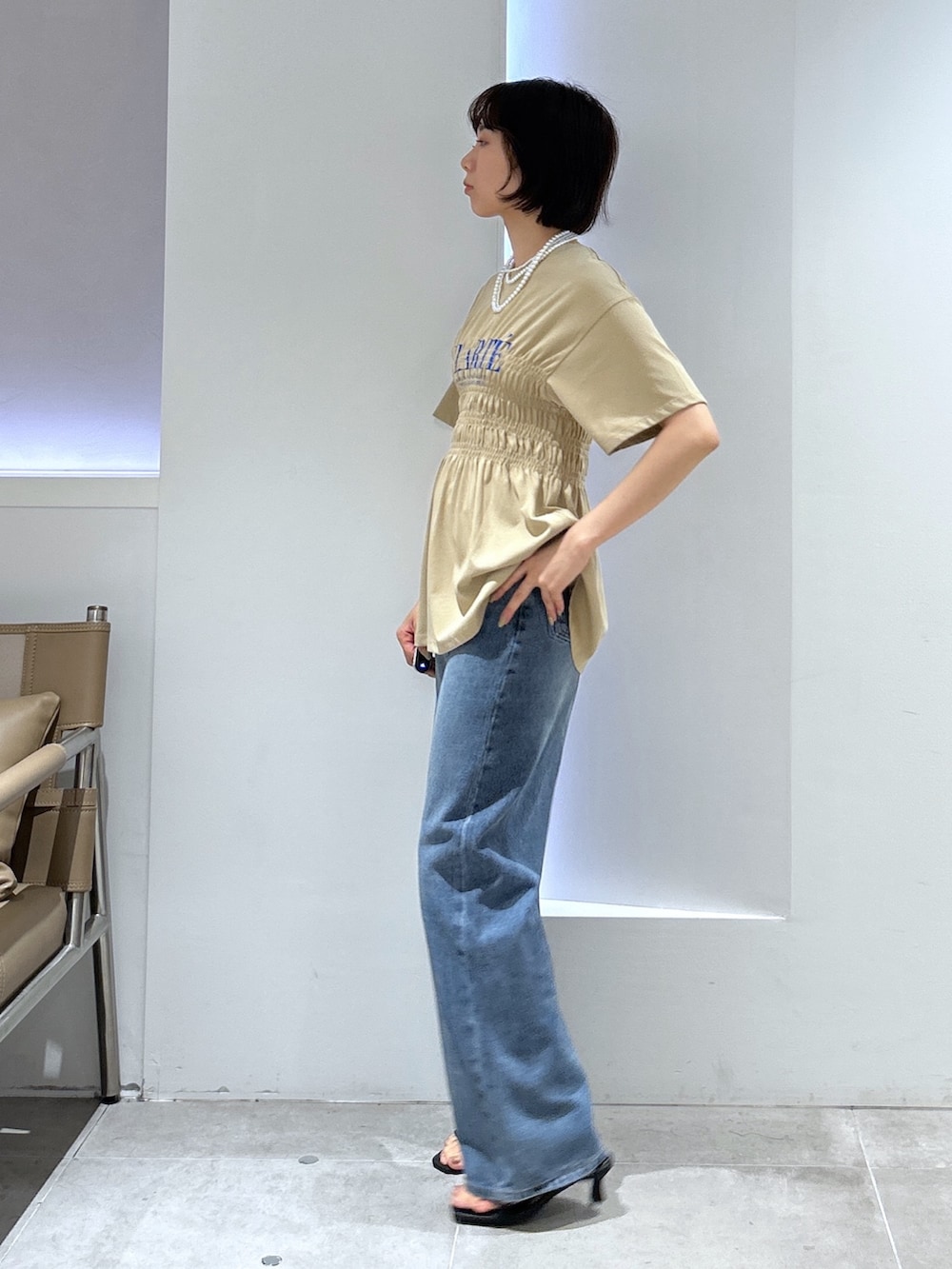 ベージュ系のTシャツ/カットソー、ブルー系のデニムパンツを着用したレディースの夏コーディネートの3枚目の写真