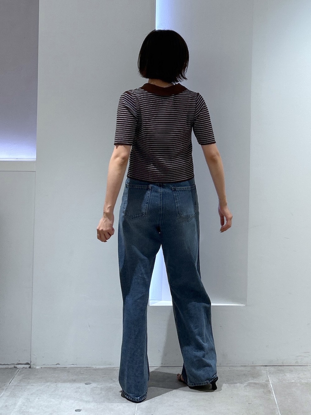 ブルー系のデニムパンツ、ブラウン系のワンピースを着用したレディースの夏コーディネートの4枚目の写真