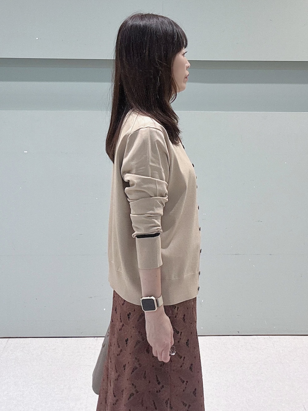 ベージュ系のカーディガン/ボレロ、ベージュ系のニット/セーター、ブラウン系のスカートを着用したレディースの秋コーディネートの8枚目の写真