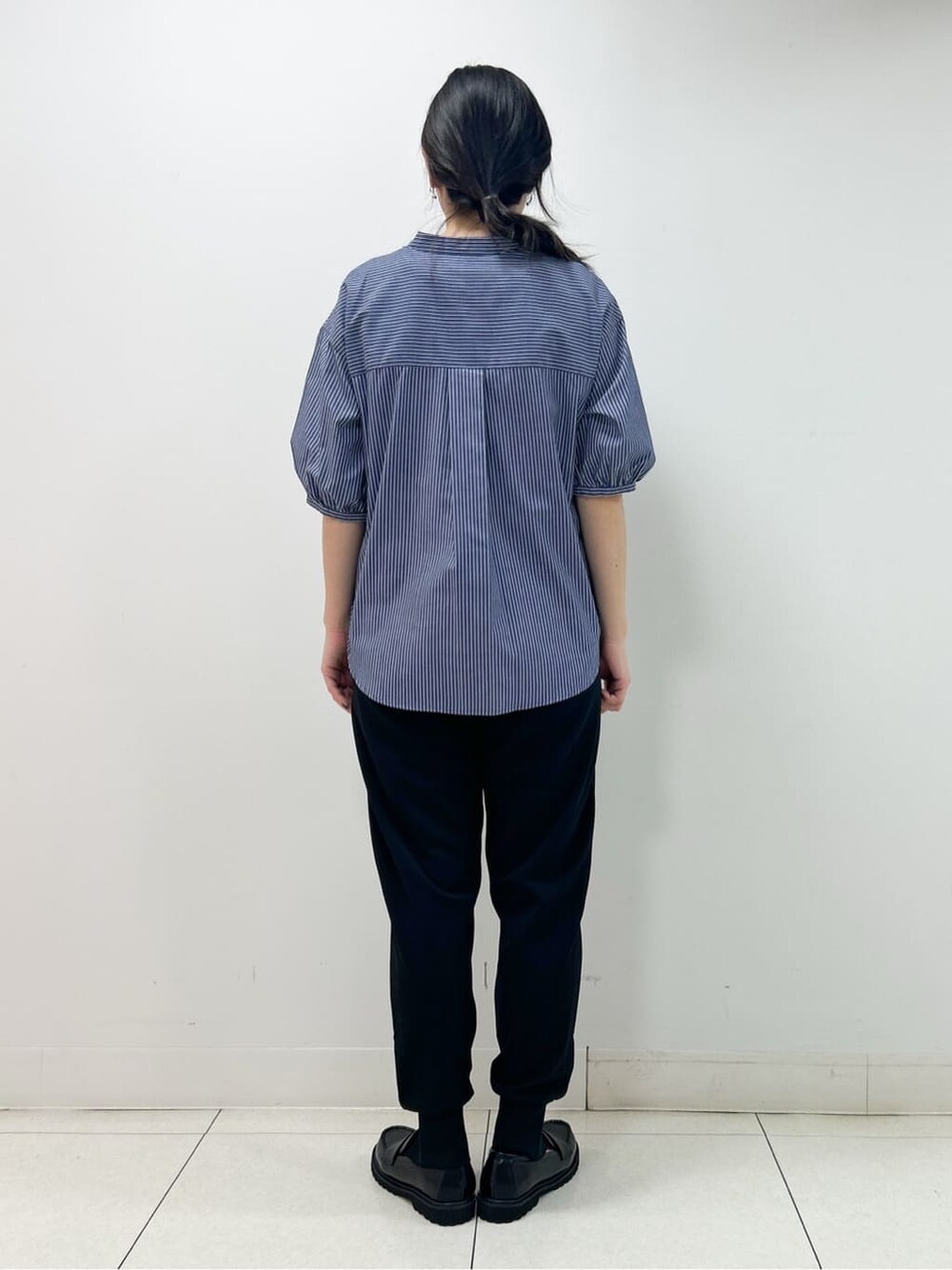 ブルー系のシャツ/ブラウス、ブラック系のその他パンツ、ブラック系のショルダーバッグを着用したレディースの秋コーディネートの3枚目の写真