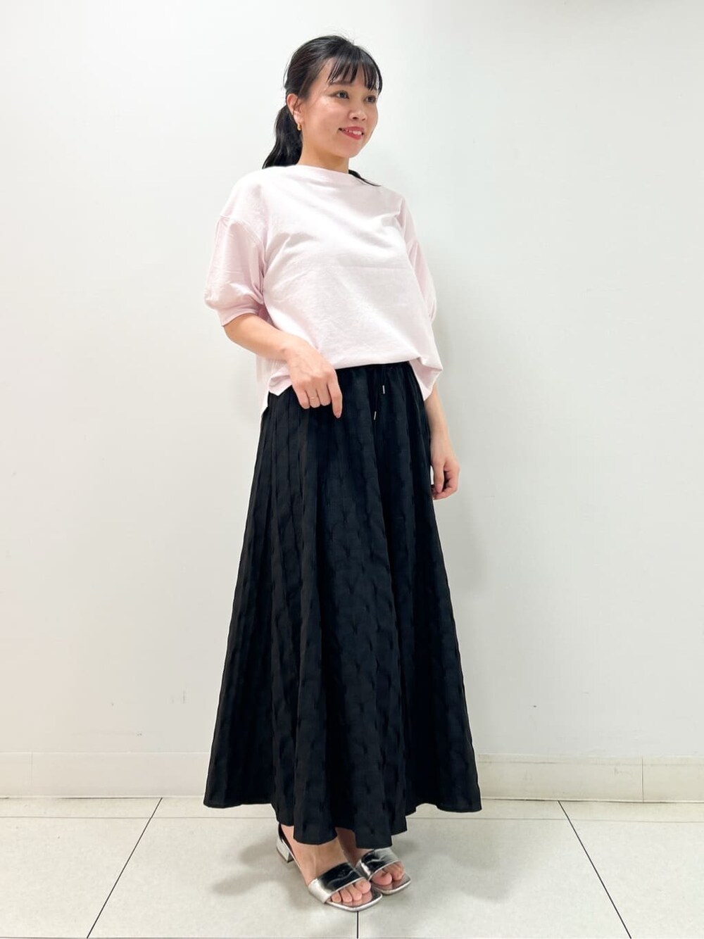 ピンク系のTシャツ/カットソー、ブラック系のスカート、ブラック系のショルダーバッグを着用したレディースの夏コーディネートの2枚目の写真