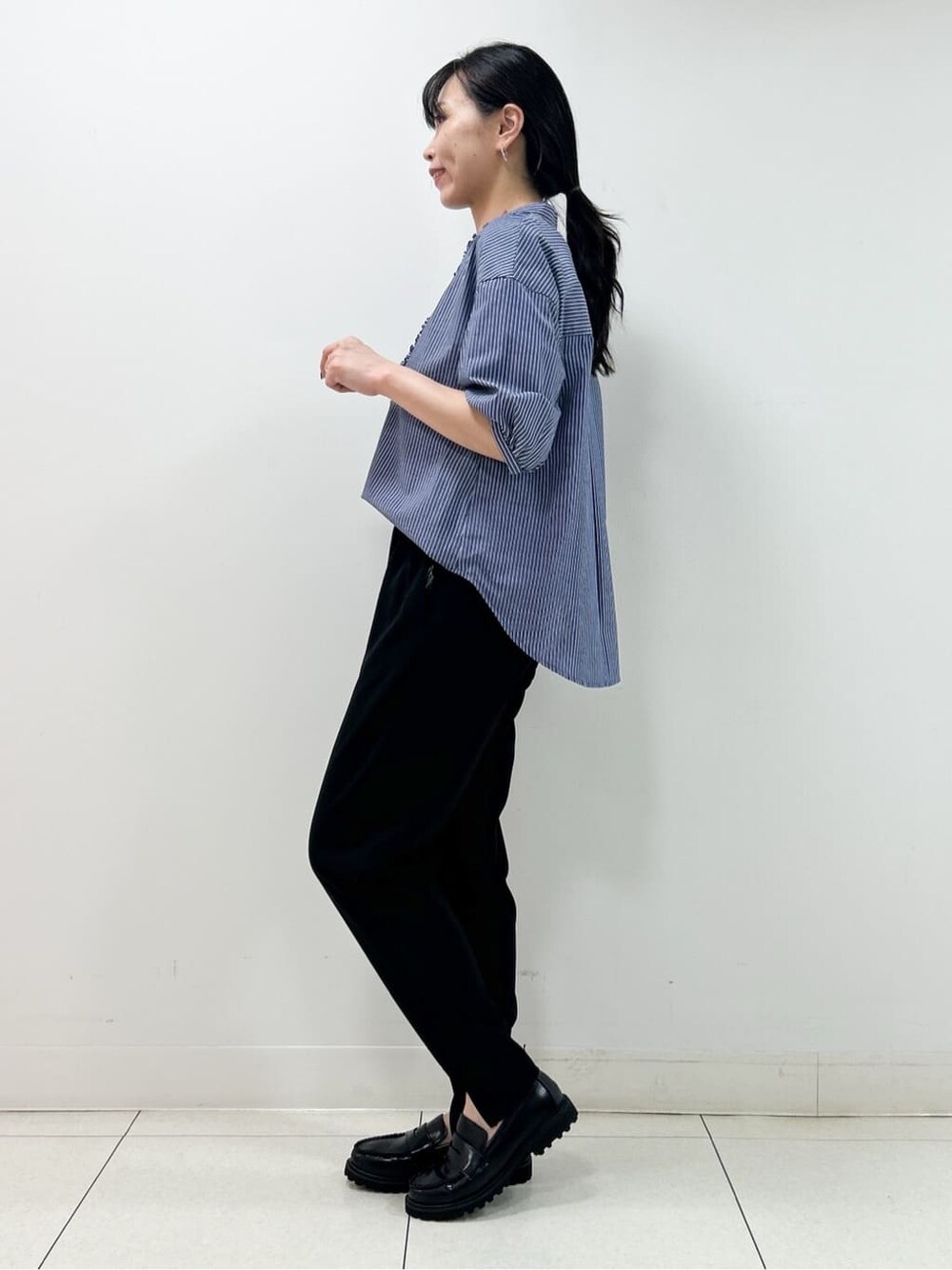 ブルー系のシャツ/ブラウス、ブラック系のその他パンツ、ブラック系のショルダーバッグを着用したレディースの秋コーディネートの4枚目の写真