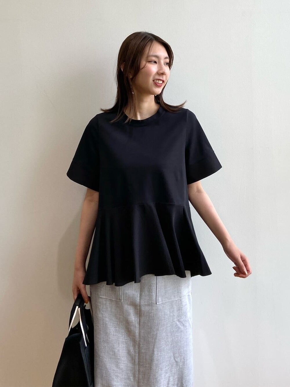 ブラック系のTシャツ/カットソー、グレー系のスカート、ブラック系のサンダルを着用したレディースの夏コーディネートの6枚目の写真
