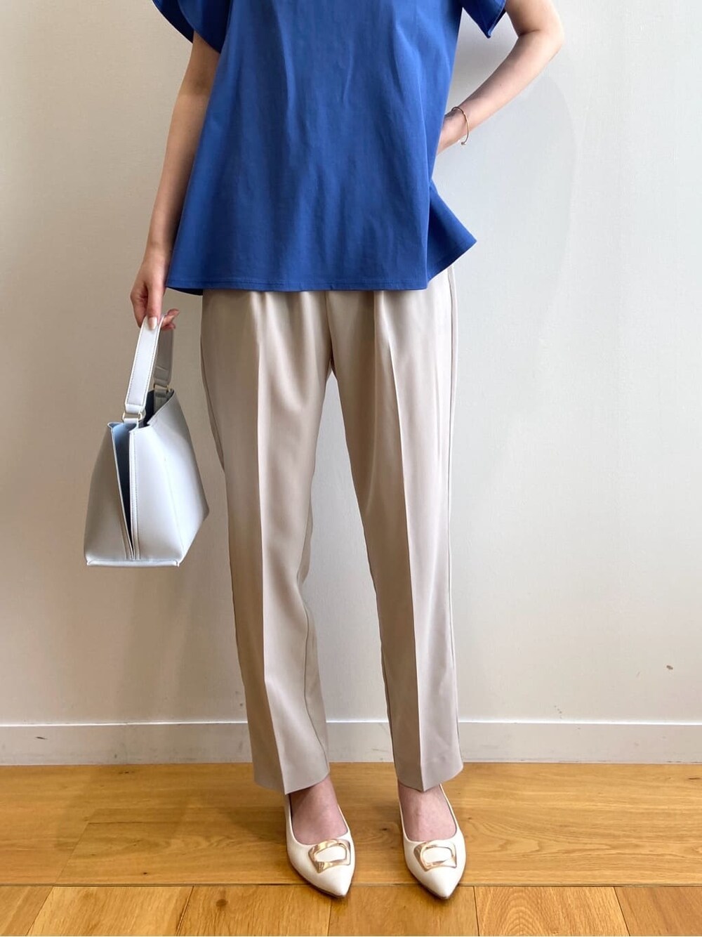 ブルー系のTシャツ/カットソー、ベージュ系のその他パンツ、グレー系のショルダーバッグを着用したレディースの春コーディネートの9枚目の写真
