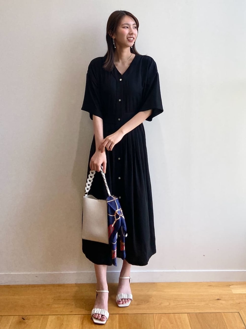 ブラック系のワンピース、ホワイト系のショルダーバッグ、ベージュ系のサンダルを着用したレディースの夏コーディネートの2枚目の写真