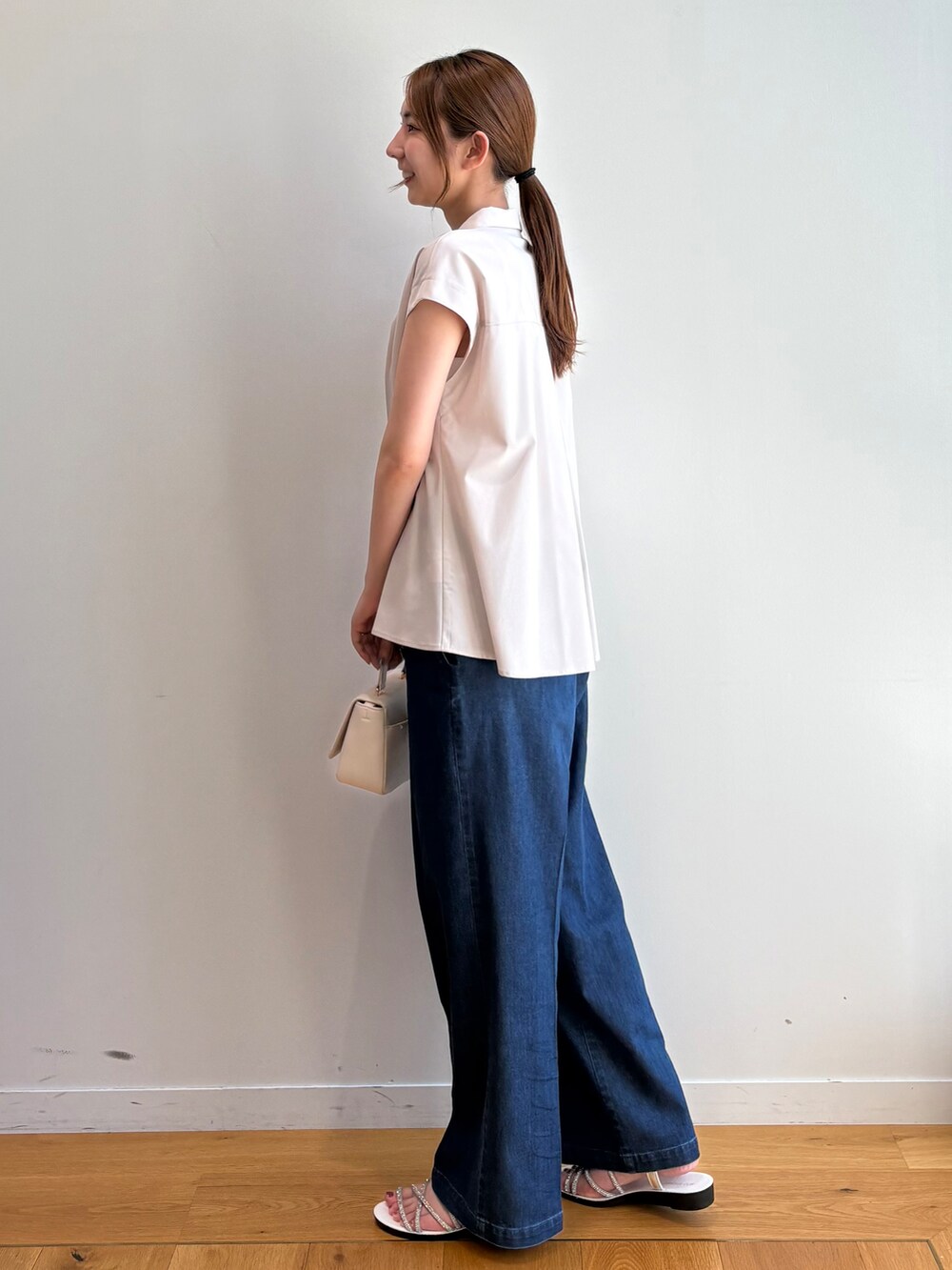 ベージュ系のシャツ/ブラウス、ブルー系のデニムパンツ、ホワイト系のショルダーバッグを着用したレディースの夏コーディネートの6枚目の写真