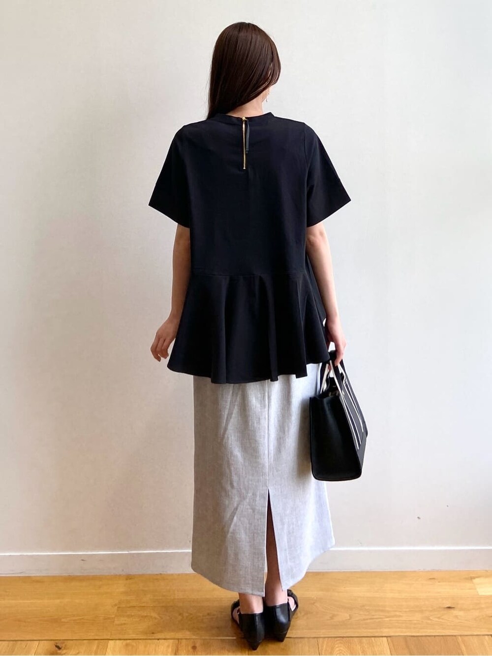 ブラック系のTシャツ/カットソー、グレー系のスカート、ブラック系のサンダルを着用したレディースの夏コーディネートの4枚目の写真