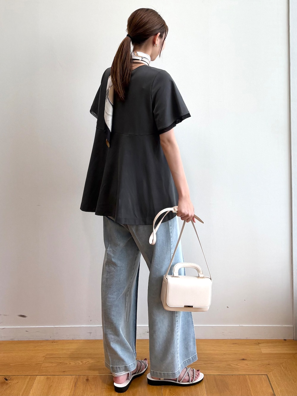 グレー系のTシャツ/カットソー、ブルー系のデニムパンツ、シルバー系のサンダルを着用したレディースの夏コーディネートの4枚目の写真