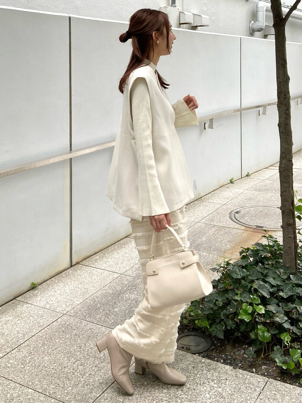 ホワイト系のその他パンツ、ホワイト系のショルダーバッグ、ベージュ系のブーツを着用したレディースの秋コーディネートの3枚目の写真