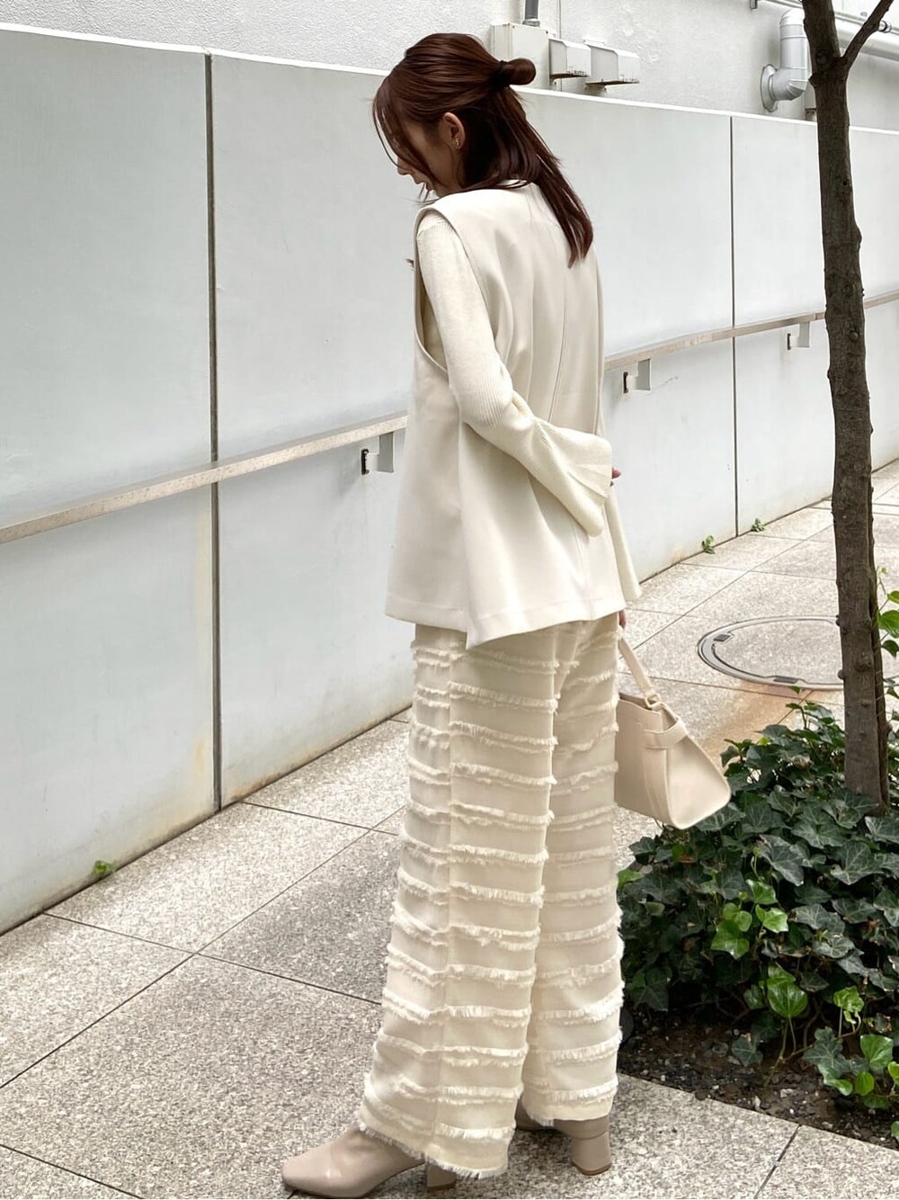 ホワイト系のその他パンツ、ホワイト系のショルダーバッグ、ベージュ系のブーツを着用したレディースの秋コーディネートの4枚目の写真