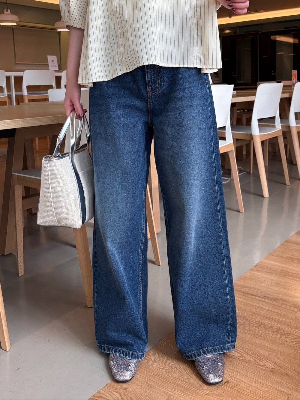 イエロー系のシャツ/ブラウス、ブルー系のデニムパンツ、シルバー系のトートバッグを着用したレディースの春コーディネートの8枚目の写真