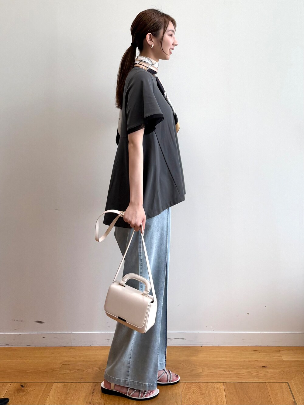 グレー系のTシャツ/カットソー、ブルー系のデニムパンツ、シルバー系のサンダルを着用したレディースの夏コーディネートの3枚目の写真