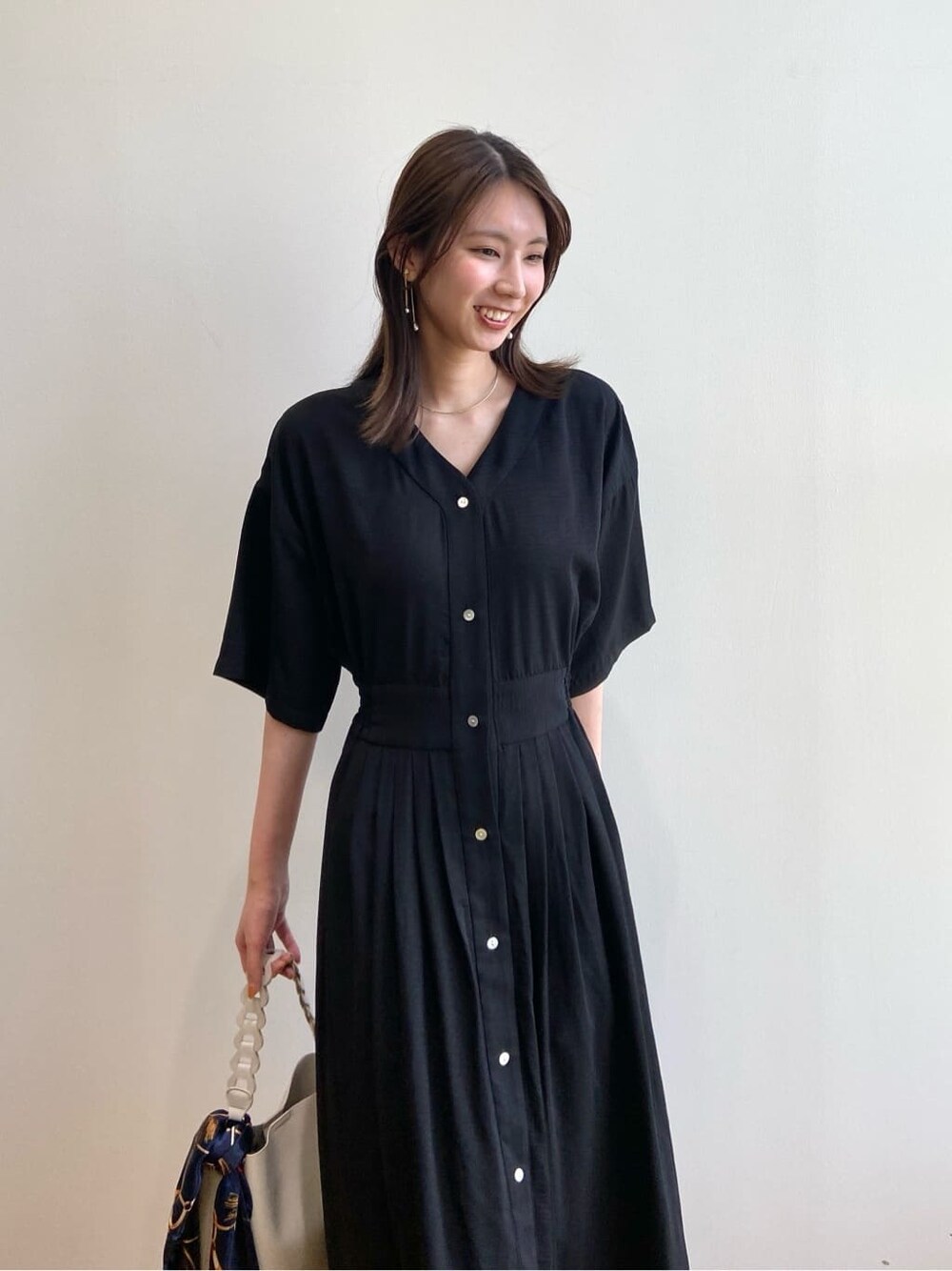 ブラック系のワンピース、ホワイト系のショルダーバッグ、ベージュ系のサンダルを着用したレディースの夏コーディネートの6枚目の写真