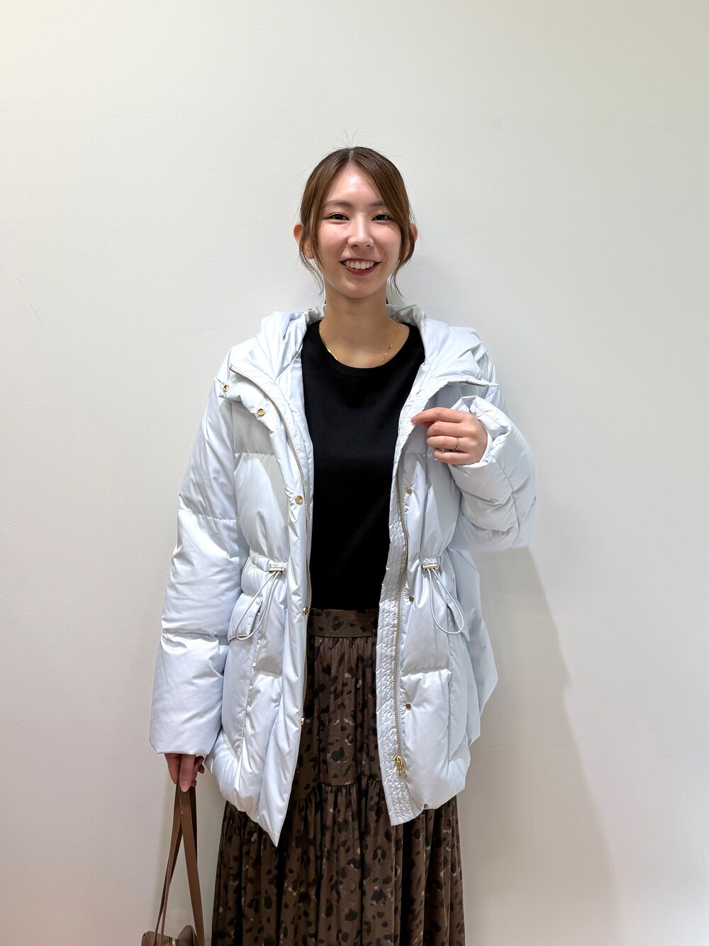 ブルー系のダウンジャケット/コート、ブラック系のニット/セーター、ブラウン系のスカートを着用したレディースの秋コーディネートの9枚目の写真