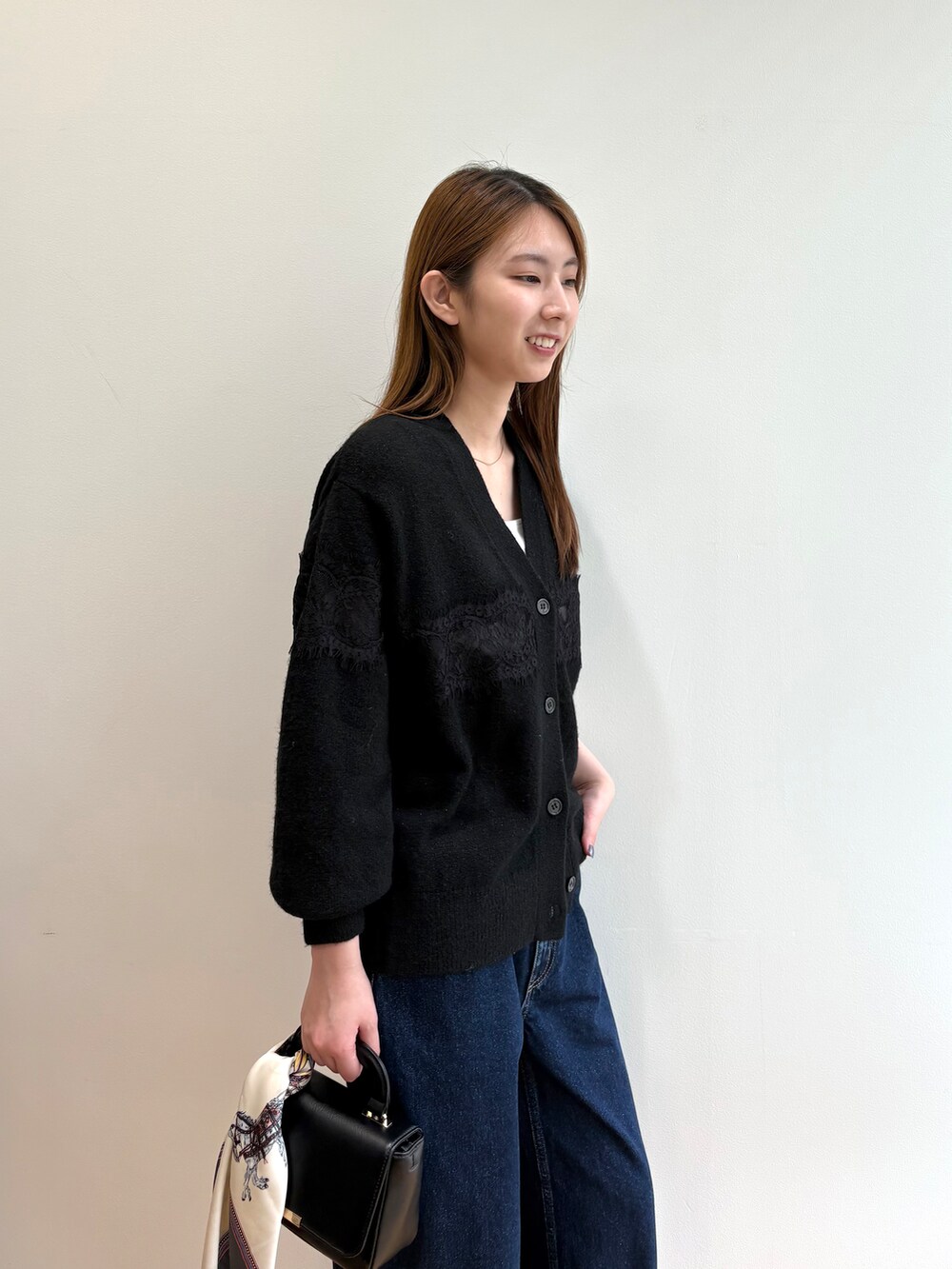ブラック系のカーディガン/ボレロ、ブルー系のデニムパンツ、ブラック系のショルダーバッグを着用したレディースの夏コーディネートの9枚目の写真