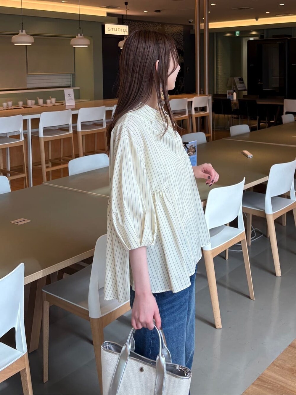 イエロー系のシャツ/ブラウス、ブルー系のデニムパンツ、シルバー系のトートバッグを着用したレディースの春コーディネートの5枚目の写真