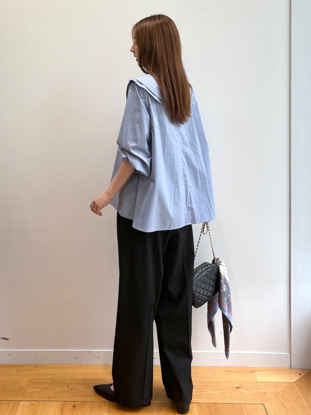 ブルー系のシャツ/ブラウス、ブラック系のショルダーバッグ、ブラック系のパンプスを着用したレディースの夏コーディネートの4枚目の写真
