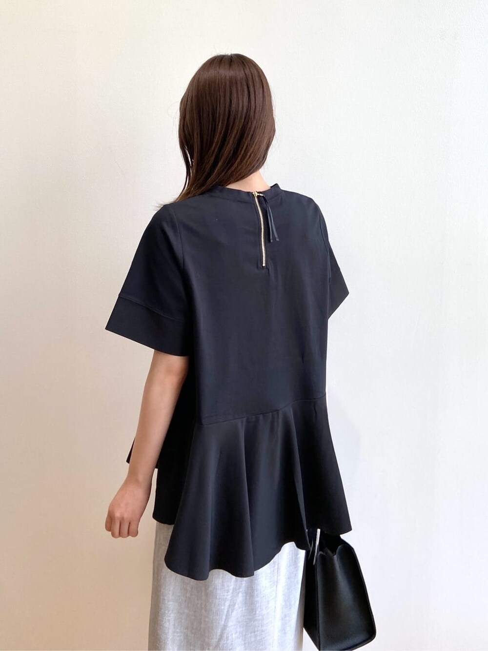 ブラック系のTシャツ/カットソー、グレー系のスカート、ブラック系のサンダルを着用したレディースの夏コーディネートの5枚目の写真