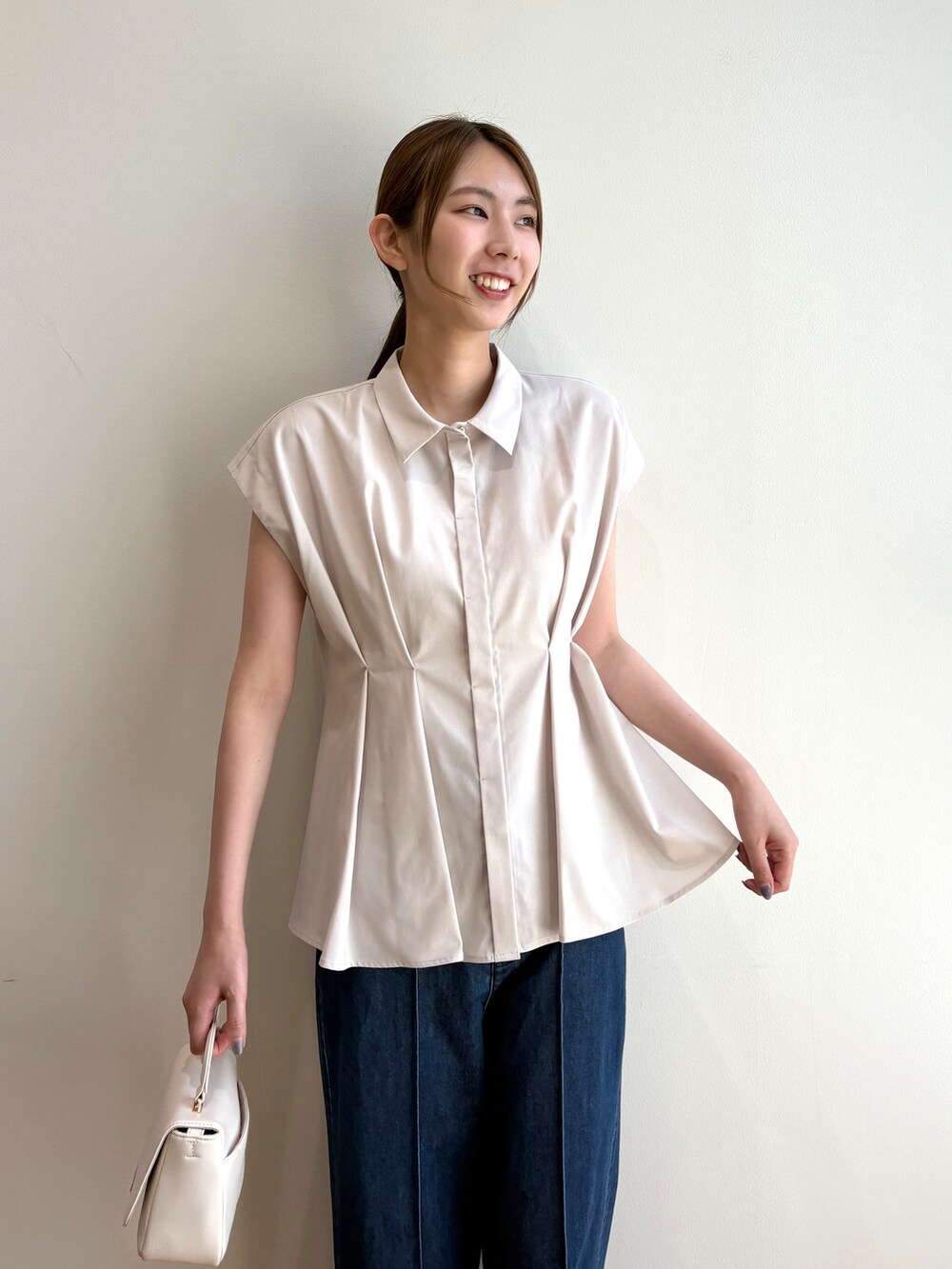 ベージュ系のシャツ/ブラウス、ブルー系のデニムパンツ、ホワイト系のショルダーバッグを着用したレディースの夏コーディネートの7枚目の写真