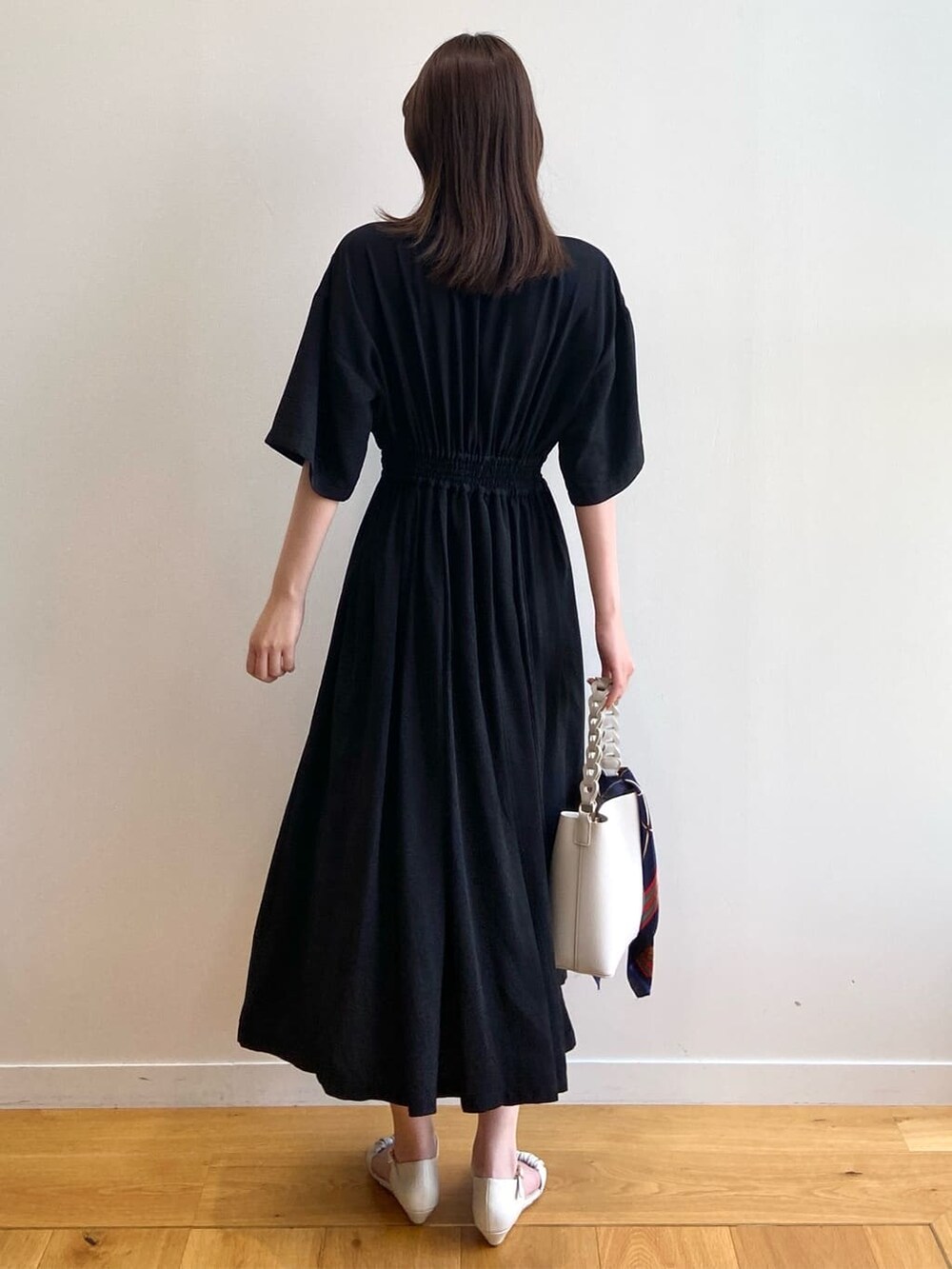 ブラック系のワンピース、ホワイト系のショルダーバッグ、ベージュ系のサンダルを着用したレディースの夏コーディネートの4枚目の写真