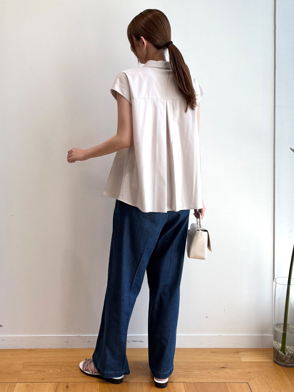 ベージュ系のシャツ/ブラウス、ブルー系のデニムパンツ、ホワイト系のショルダーバッグを着用したレディースの夏コーディネートの5枚目の写真