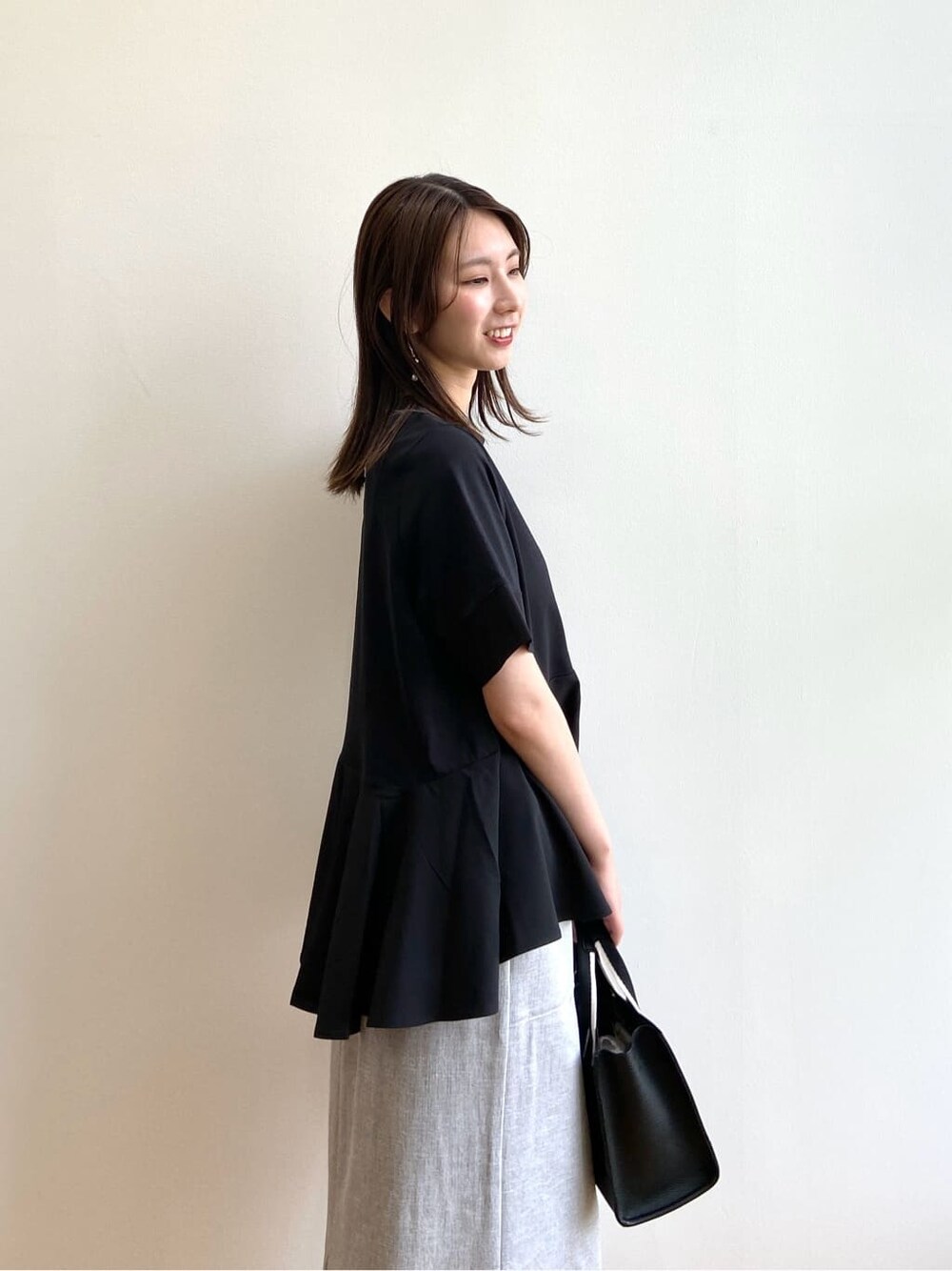 ブラック系のTシャツ/カットソー、グレー系のスカート、ブラック系のサンダルを着用したレディースの夏コーディネートの7枚目の写真