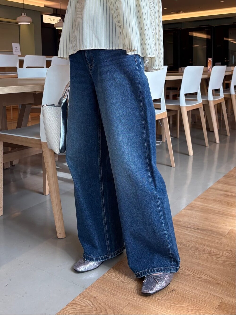 イエロー系のシャツ/ブラウス、ブルー系のデニムパンツ、シルバー系のトートバッグを着用したレディースの春コーディネートの9枚目の写真