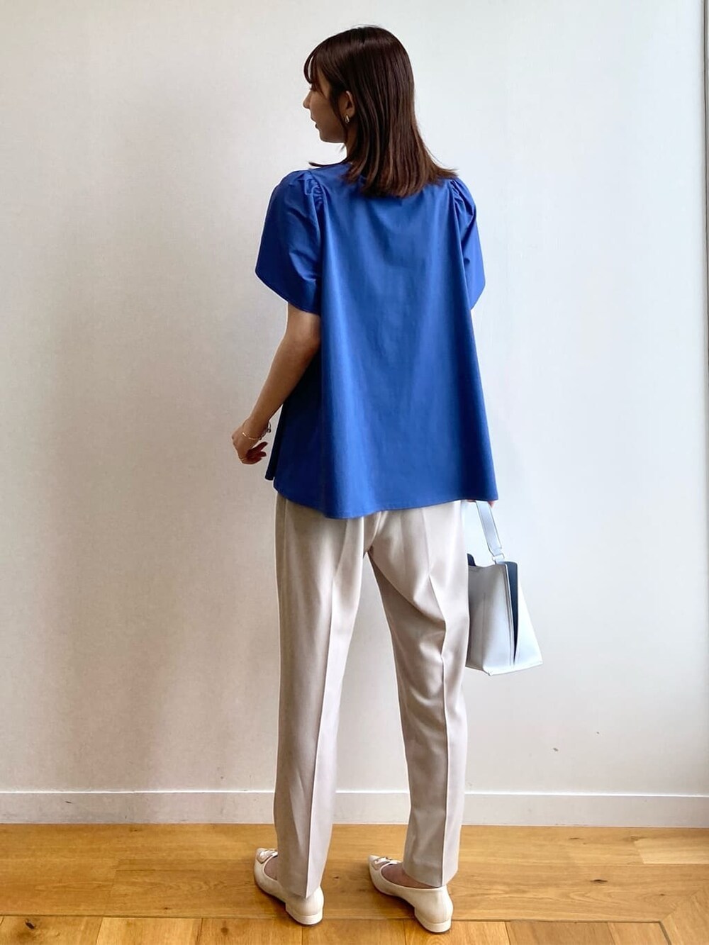 ブルー系のTシャツ/カットソー、ベージュ系のその他パンツ、グレー系のショルダーバッグを着用したレディースの春コーディネートの5枚目の写真