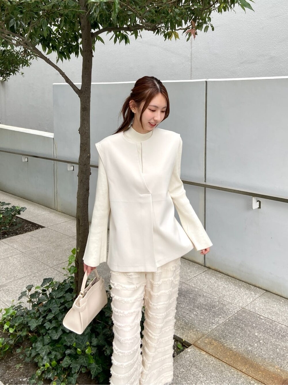 ホワイト系のその他パンツ、ホワイト系のショルダーバッグ、ベージュ系のブーツを着用したレディースの秋コーディネートの6枚目の写真