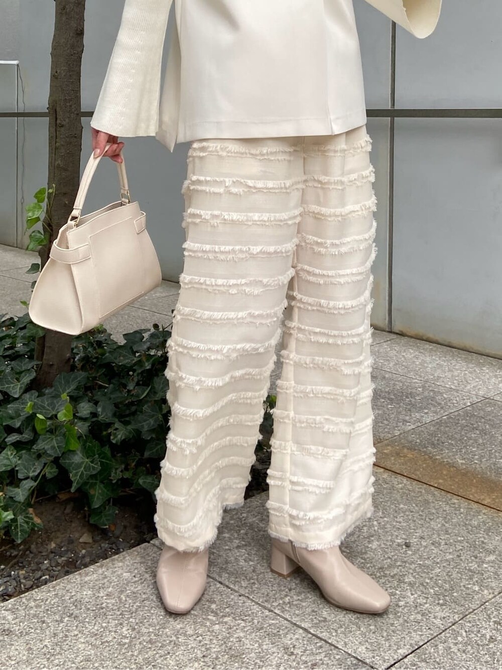 ホワイト系のその他パンツ、ホワイト系のショルダーバッグ、ベージュ系のブーツを着用したレディースの秋コーディネートの10枚目の写真