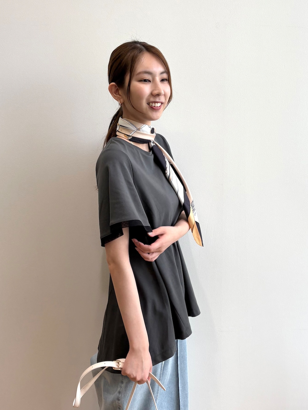 グレー系のTシャツ/カットソー、ブルー系のデニムパンツ、シルバー系のサンダルを着用したレディースの夏コーディネートの5枚目の写真