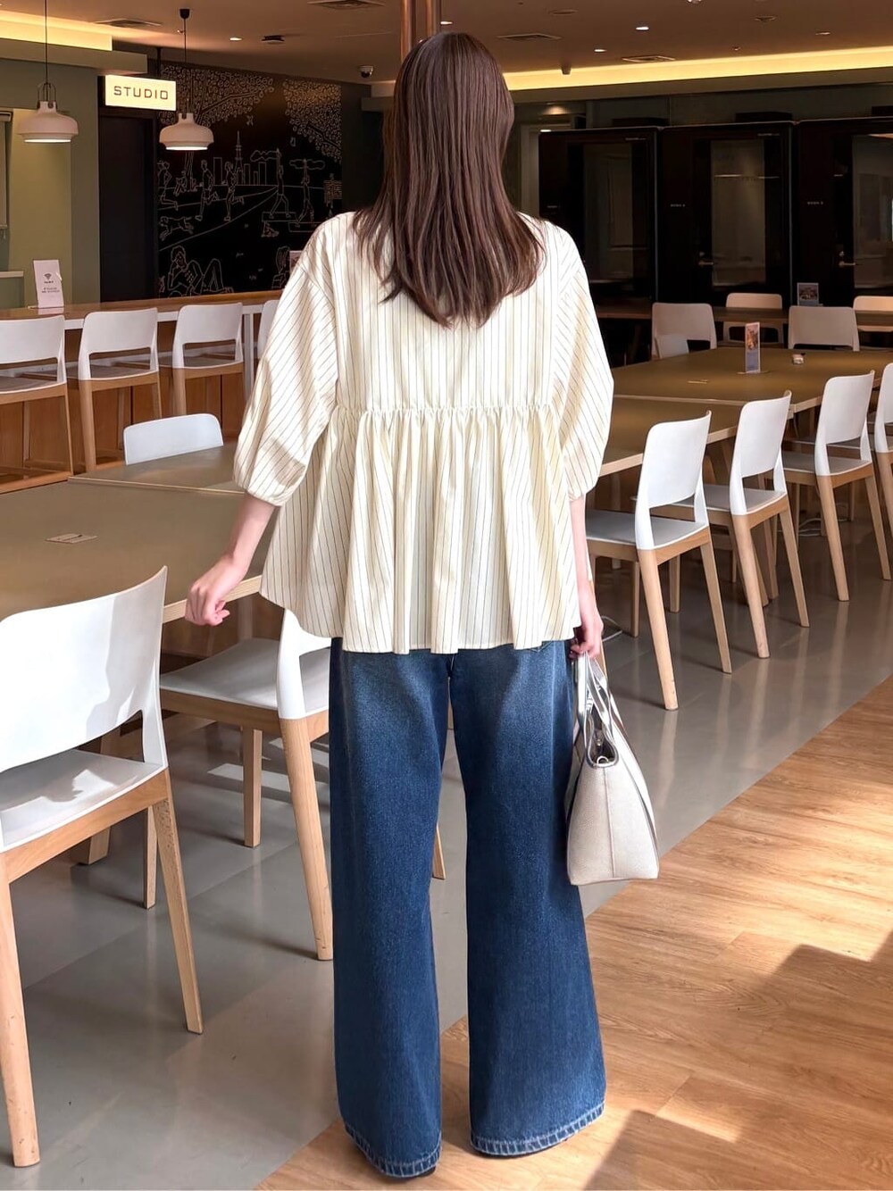 イエロー系のシャツ/ブラウス、ブルー系のデニムパンツ、シルバー系のトートバッグを着用したレディースの春コーディネートの4枚目の写真