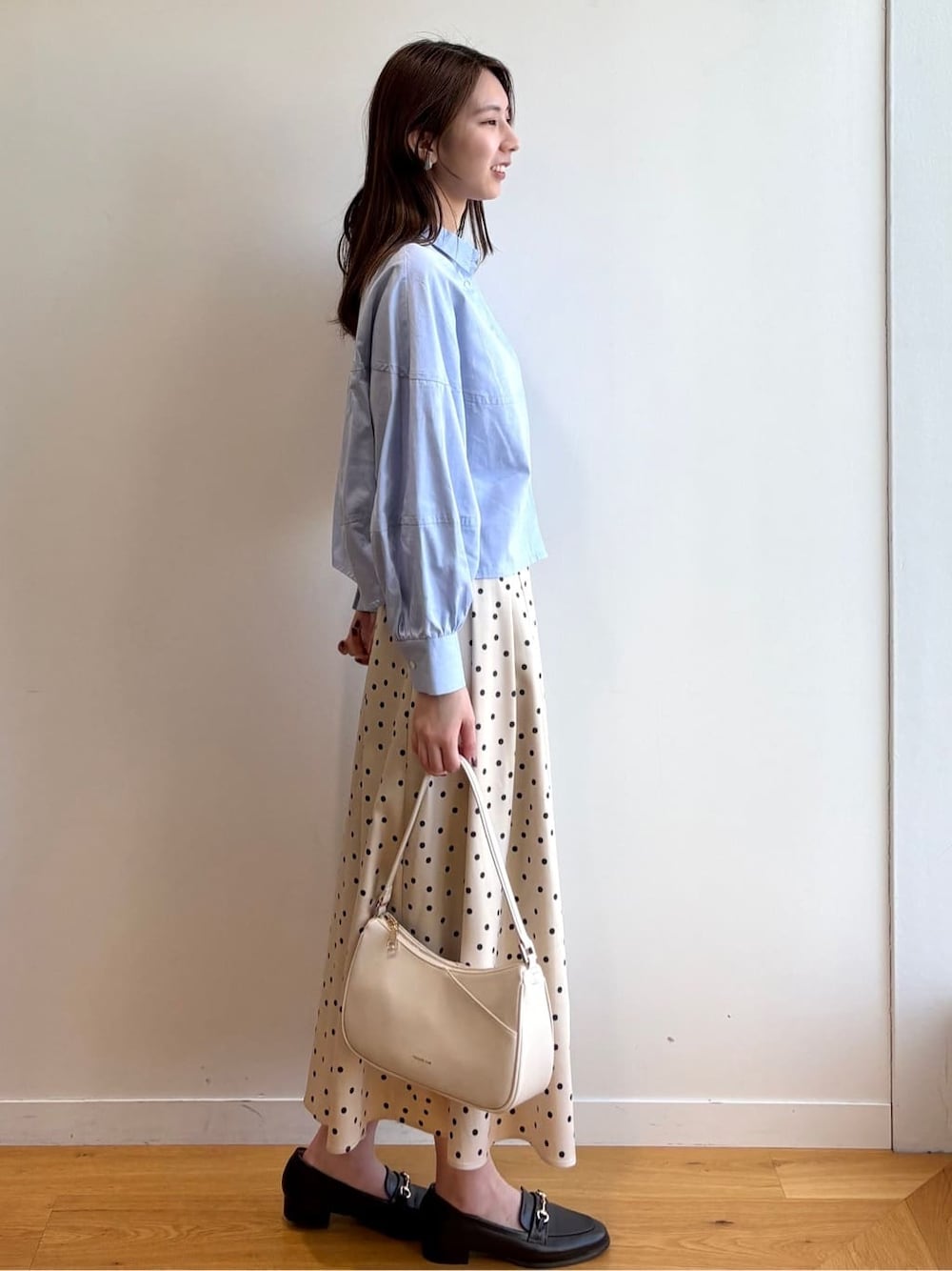 ブルー系のシャツ/ブラウス、ベージュ系のスカート、ホワイト系のショルダーバッグを着用したレディースの冬コーディネートの3枚目の写真