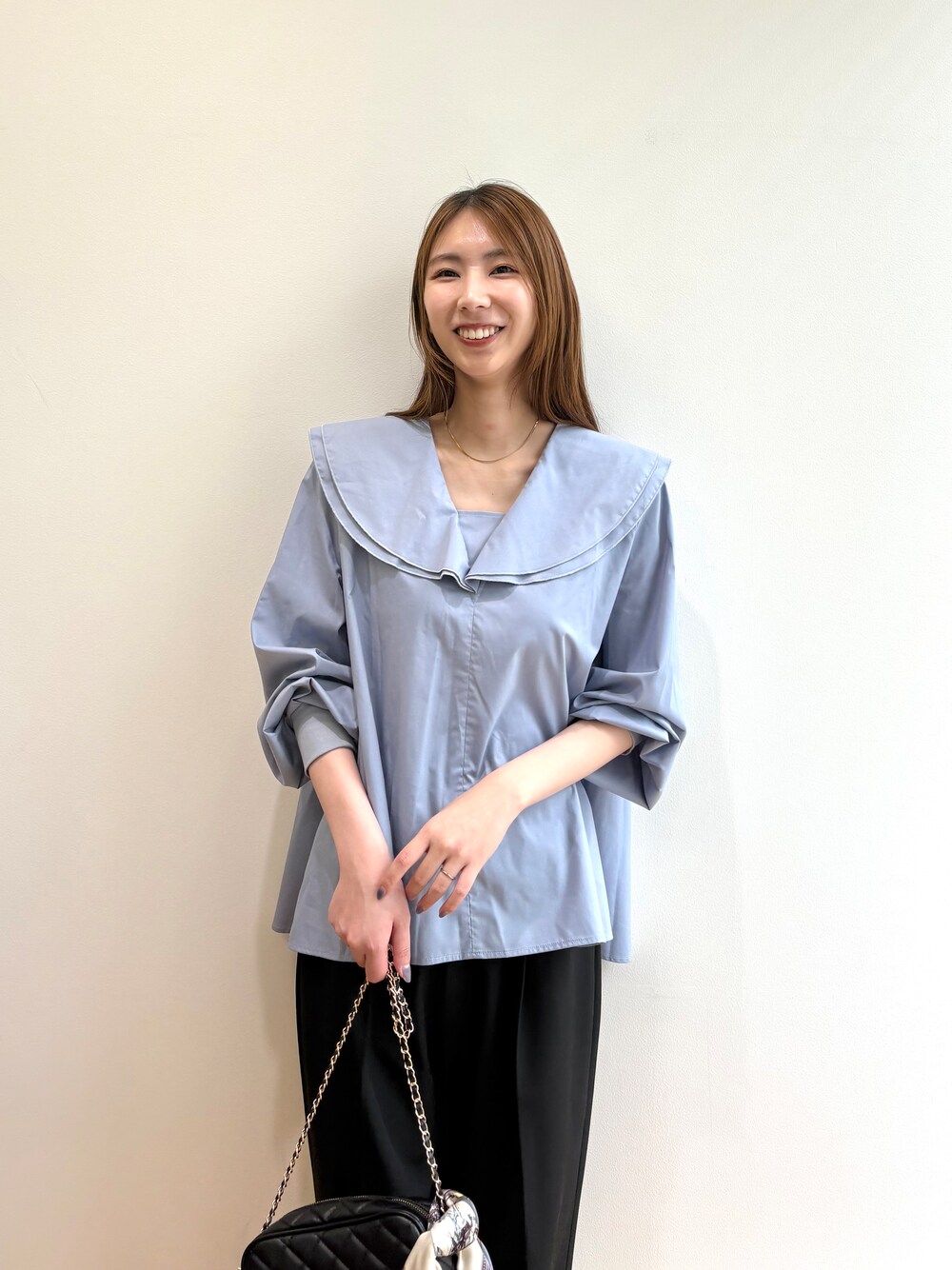 ブルー系のシャツ/ブラウス、ブラック系のショルダーバッグ、ブラック系のパンプスを着用したレディースの夏コーディネートの5枚目の写真