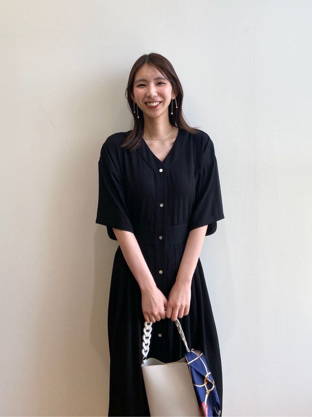 ブラック系のワンピース、ホワイト系のショルダーバッグ、ベージュ系のサンダルを着用したレディースの夏コーディネートの5枚目の写真