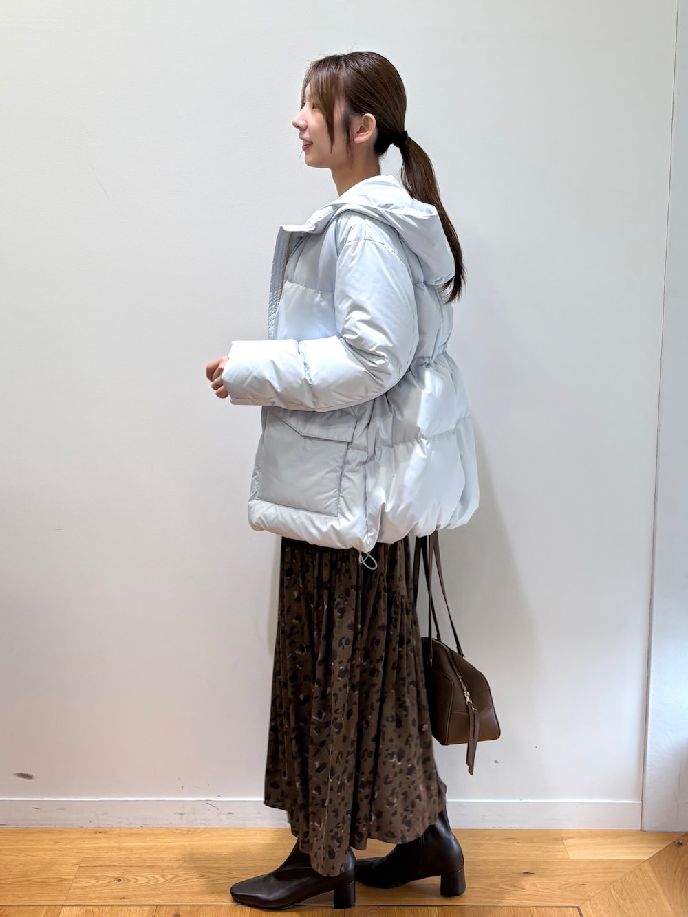 ブルー系のダウンジャケット/コート、ブラック系のニット/セーター、ブラウン系のスカートを着用したレディースの秋コーディネートの8枚目の写真